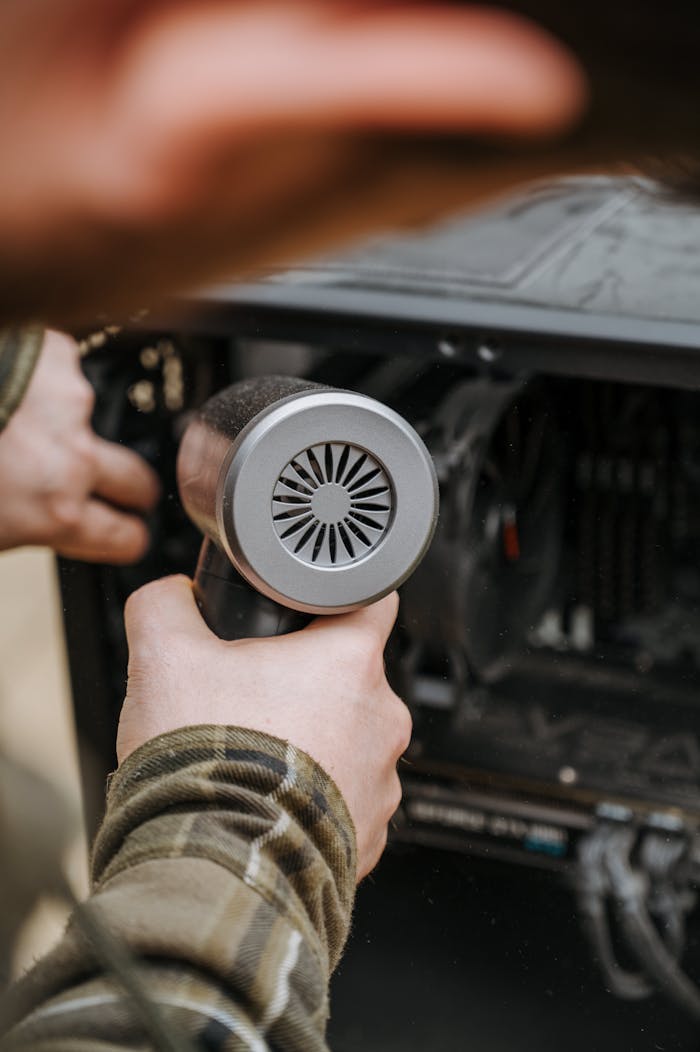 journey Close-up of an adult cleaning a computer's interior with an air duster for maintenance.